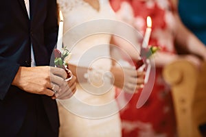 Happy bride and stylish groom holding candles wedding ceremony, wedding couple at matrimony in church, emotional moment, religion