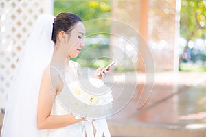 Happy bride talking on cell phone in wedding dress