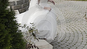 Happy bride walks on the paving slabs.