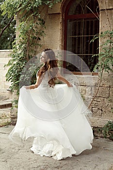 Happy bride woman running in wedding dress at park