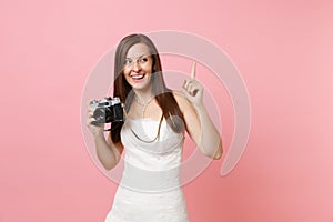 Happy bride woman in wedding dress pointing index finger up holding retro vintage photo camera choosing staff