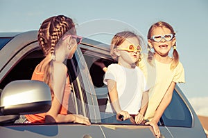 Happy brother and his two sisters are sitting in the car