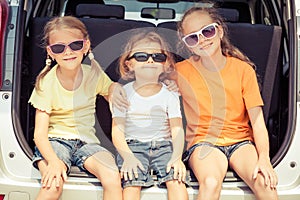 Happy brother and his two sisters are sitting in the car