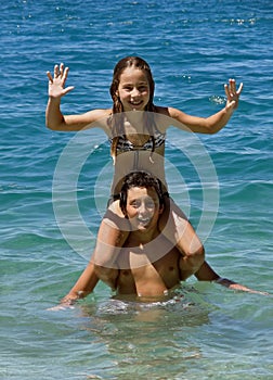 Happy brother and sister in fun on sea