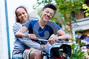 Happy brother and sister riding motorcycle