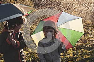 Happy brother with umbrella outdoors