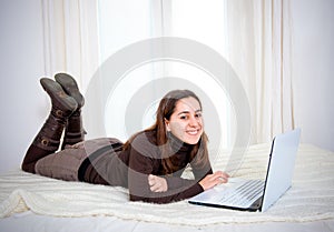 Happy brown hair latin woman working on her laptop