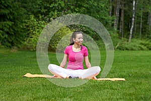 Happy brown haired girl stretching inner muscles of hips sitting on mat. photo