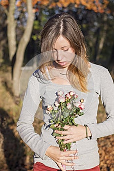 Happy brunette girl holding miniature roses