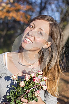 Happy brunette girl holding miniature roses