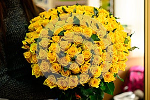 Happy brunette girl received big bouquet of beautiful fresh yell