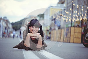 Happy brunette woman lies on the road in the city free and unchained