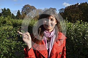 Happy brunette woman in red coat smiling and holding a set of keys