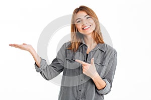 Happy brunette woman in shirt holding copyspace on the palm