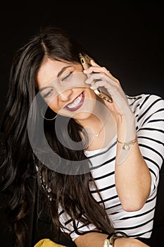 Happy brunette woman talking on her cell phone smiling looking d