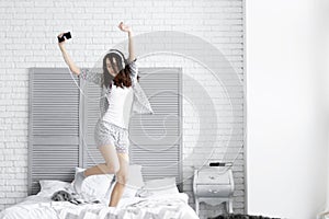 Happy brunette woman wears grey pajamas. Morning concept