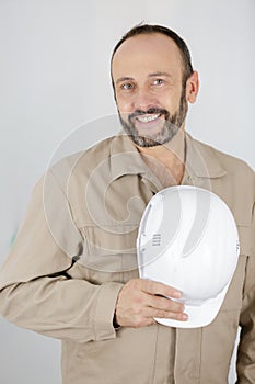 Happy builder holding helmet