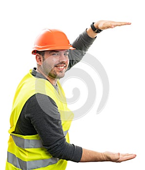Happy builder man presenting object copyspace between hands