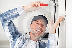 happy builder with screwdriver and cables