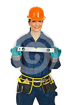 Happy builder woman holding bubble level