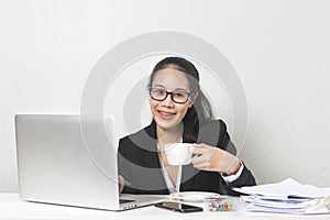 Asiático una mujer en negocios computadora portátil sobre el blanco en negocios mesa diligente profesionalmente en negocios una mujer bebiendo café mientras en negocios sobre el notas 