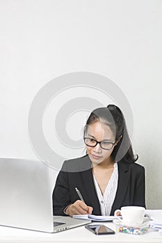 Happy business Asian woman working with laptop at white working table