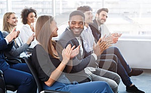 Happy business colleagues clapping hands at conference