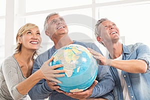 Happy business colleagues holding terrestrial globe