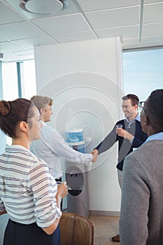 Happy business colleagues shaking hands at office