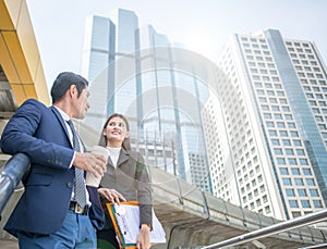 Happy Business colleagues talk outside office & talking to each other. Businessman talk and hold coffee cup.