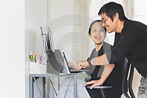 Happy business couple working on computer together at home.