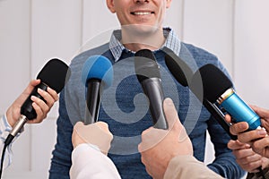 Happy business man giving interview to journalists at official event