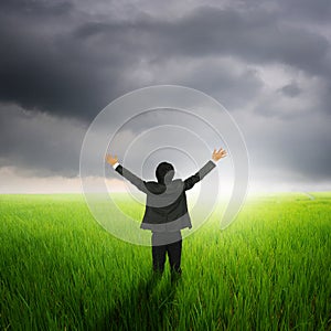 Happy business man in green rice field and rainclouds