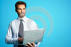 Happy business man with a laptop - isolated over a blue background