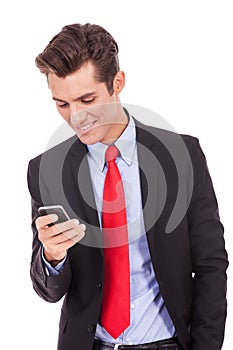 Happy business man reading an SMS on smartphone