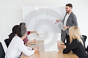 happy business man smiling and making a presentation on whiteboard and pointing on the chart . boss presenting strategy of