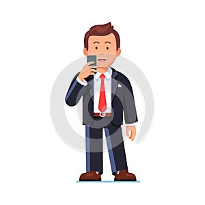 Happy business man standing with mobile phone