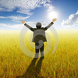 Happy Business Man standing in Yellow rice field and sun sky