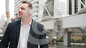 Happy business man using headphone listening relax music and move along. Urbane.