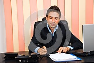 Happy business man write on paper in office