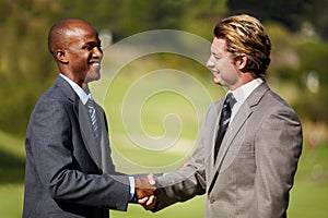 Happy business men, shaking hands and outdoor for agreement, welcome or teamwork in diversity. Businessman, hand shake
