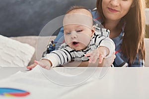 Young mother working and spending time with baby