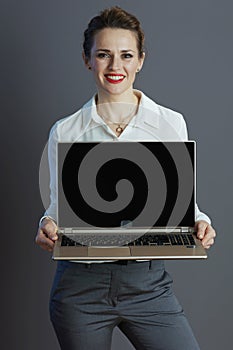 happy business owner woman showing laptop blank screen