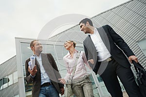 Happy Business Partners And Client Walking Outside Office