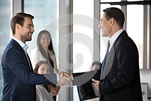 Happy business partners handshake congratulating with deal closing