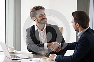 Happy business partners handshaking after successful meeting