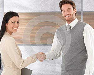 Happy business partners shaking hands