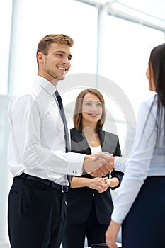 Happy business partners shaking hands in an office