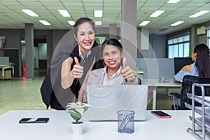 Happy business people business team showing thumbs up sign and looking at camera