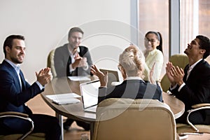 Happy business people congratulating partner woman in office at